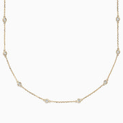 The 14K Yellow Gold 18 Diamond Station Necklace, 1.00 TCW, features small round bezel-set diamonds spaced along a delicate gold chain for an elegant, minimalist look.