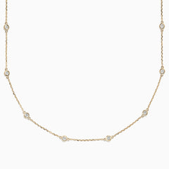 The 14K Yellow Gold 18 Diamond Station Necklace, 1.00 TCW, features small round bezel-set diamonds spaced along a delicate gold chain for an elegant, minimalist look.