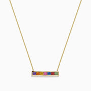 The Watercolors 14K Yellow Gold Multi Sapphire Bar Necklace, 0.93 TCW, features a delicate gold bar with six rainbow-arranged sapphires set in a horizontal rectangular pendant.