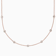The Pave Rose 14K Rose Gold Diamond Station Necklace, 0.69 TCW, features round bezel-set diamonds spaced along a fine rose gold chain and is displayed on a plain white background.