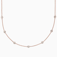 The Pave Rose 14K Rose Gold Diamond Station Necklace, 0.69 TCW, features round bezel-set diamonds spaced along a fine rose gold chain and is displayed on a plain white background.