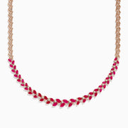 The Ruby Royale 14K Yellow Gold Ruby and Diamond Leaf Necklace showcases a leaf-inspired design with alternating rubies and diamonds in front, smoothly transitioning to a sleek yellow gold pattern at the back.