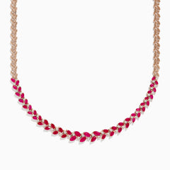 The Ruby Royale 14K Yellow Gold Ruby and Diamond Leaf Necklace showcases a leaf-inspired design with alternating rubies and diamonds in front, smoothly transitioning to a sleek yellow gold pattern at the back.