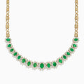 The Brasilica 14K Yellow Gold Emerald and Diamond Necklace features a row of oval emeralds, each accented by clusters of sparkling diamonds, set on an ornate yellow gold chain.