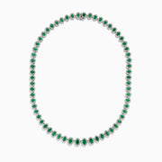 The 14K White Gold Emerald and Diamond Tennis Necklace showcases oval green emeralds, each surrounded by sparkling diamonds, evenly set along a white gold chain displayed on a white background.