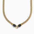 The Signature 14K Gold Black Diamond and Emerald Panther Necklace, 1.27 showcases two black panther heads with emerald eyes facing each other and holding a gold ring at the center in a textured design.