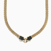 The Signature 14K Gold Black Diamond and Emerald Panther Necklace, 1.27 showcases two black panther heads with emerald eyes facing each other and holding a gold ring at the center in a textured design.