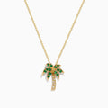 The Novelty 14K Yellow Gold Emerald and Diamond Palm Tree Pendant features emerald gemstone leaves and diamond-accented trunk, displayed on a plain white background.