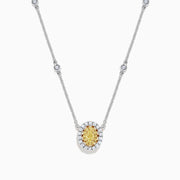 The Canare 14K White Gold Oval Halo Yellow Diamond Pendant Necklace, 0.81 TCW, features a central oval yellow diamond surrounded by clear stones on a silver chain for an elegant, radiant look.