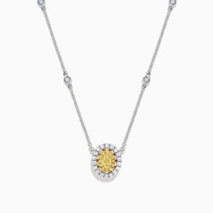 The Canare 14K White Gold Oval Halo Yellow Diamond Pendant Necklace, 0.81 TCW, features a central oval yellow diamond surrounded by clear stones on a silver chain for an elegant, radiant look.