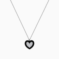 The Novelty 14K White Gold Black Enamel & Diamond Heart Pendant, 0.18 TCW, hangs from a delicate silver chain and features a heart outlined in black enamel with sparkling diamonds at the center.