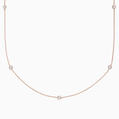 The Pave Rose 14K Rose Gold Diamond Station Necklace (0.62 TCW) features delicately bezel-set round diamonds, offering a minimal and elegant look against a plain white background.