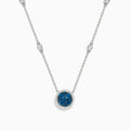 The Bella Bleu 14K White Gold White and Blue Diamond Stationary Necklace features a circular pendant with clustered blue diamonds surrounded by white diamonds, and a chain accented with additional sparkling white diamonds.