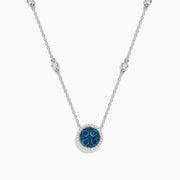 The Bella Bleu 14K White Gold White and Blue Diamond Stationary Necklace features a circular pendant with clustered blue diamonds surrounded by white diamonds, and a chain accented with additional sparkling white diamonds.