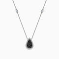 The 14K White Gold Black and White Diamond Pear Shaped Necklace, 1.09 TCW, features a teardrop pendant with black and white diamonds at the center, haloed by clear stones, plus two small clear stones set along the chain.