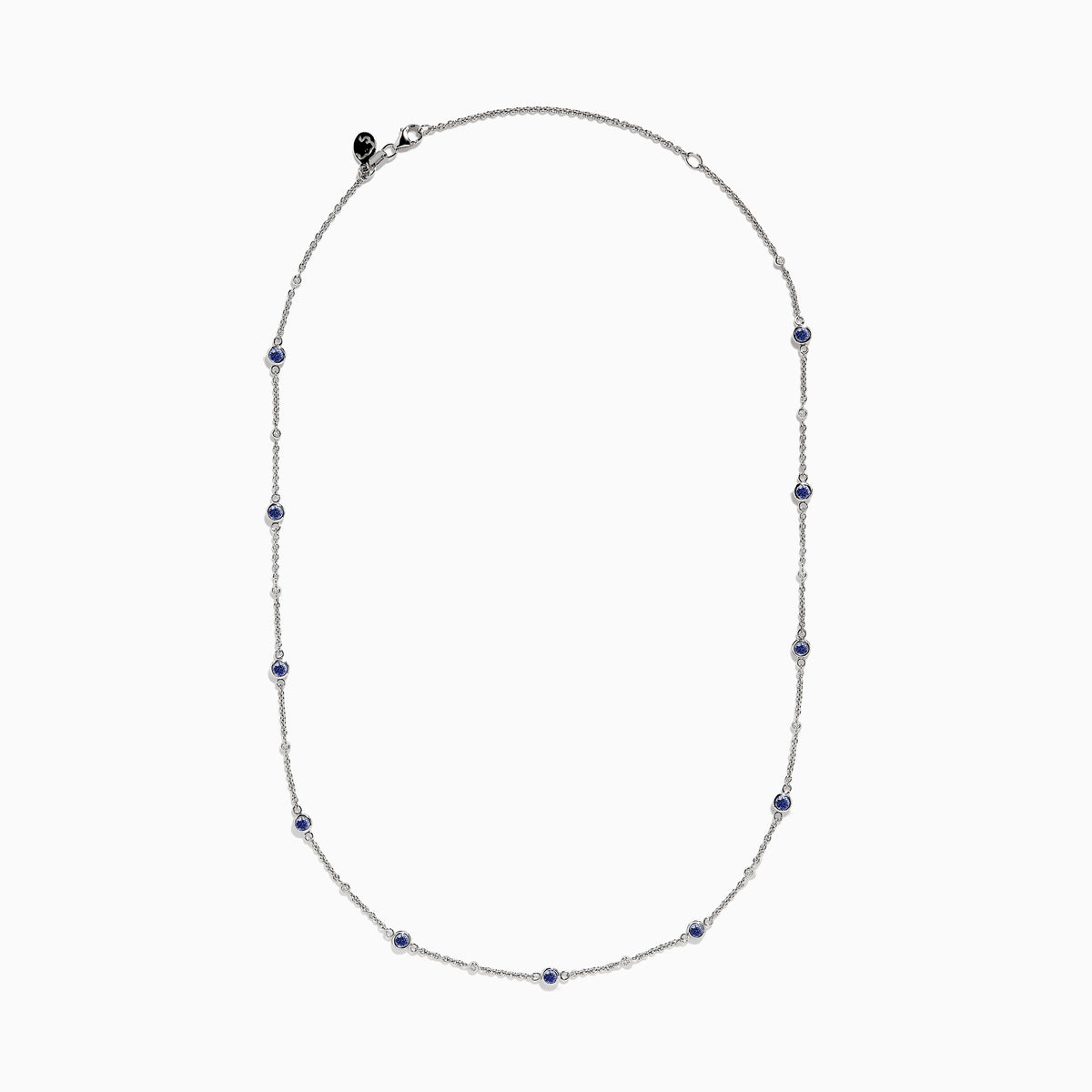 The 14K White Gold Diamond and Tanzanite Stationary Necklace showcases alternating round tanzanite and diamond gems set along a fine chain, displayed against a white background.