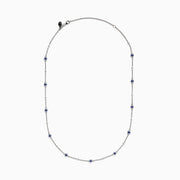 The 14K White Gold Diamond and Tanzanite Stationary Necklace showcases alternating round tanzanite and diamond gems set along a fine chain, displayed against a white background.