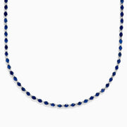 The 925 Sterling Silver Blue Sapphire Tennis Necklace features a continuous line of round blue sapphires set in sterling silver, creating a simple and elegant design.