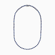 The 925 Sterling Silver Blue Sapphire Tennis Necklace features a continuous line of round blue sapphires set in sterling silver, creating a simple and elegant design.