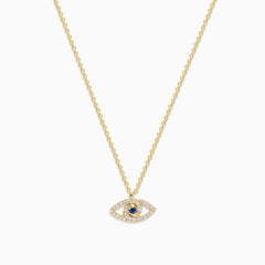 The Novelty 14K Yellow Gold Sapphire and Diamond Evil Eye Pendant features an eye-shaped design with sparkling stones and a central sapphire, resembling a classic talisman necklace.