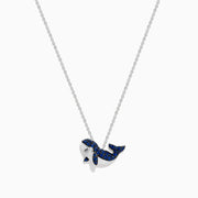 A 14K white gold necklace featuring a whale-shaped pendant adorned with sapphires and diamonds, suspended on a delicate chain.