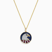 The Novelty 14K Gold Ruby, Sapphire & Diamond Eagle Head Pendant (1.06 TCW) features a round pendant with a stylized eagle head and patriotic background, embellished with ruby, sapphire, and diamond stones.