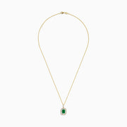 The 14K Yellow Gold Baguette Diamond Halo Emerald Pendant features a rectangular emerald framed by baguette and round diamonds, set in yellow gold with a decorative border, displayed against a white background.