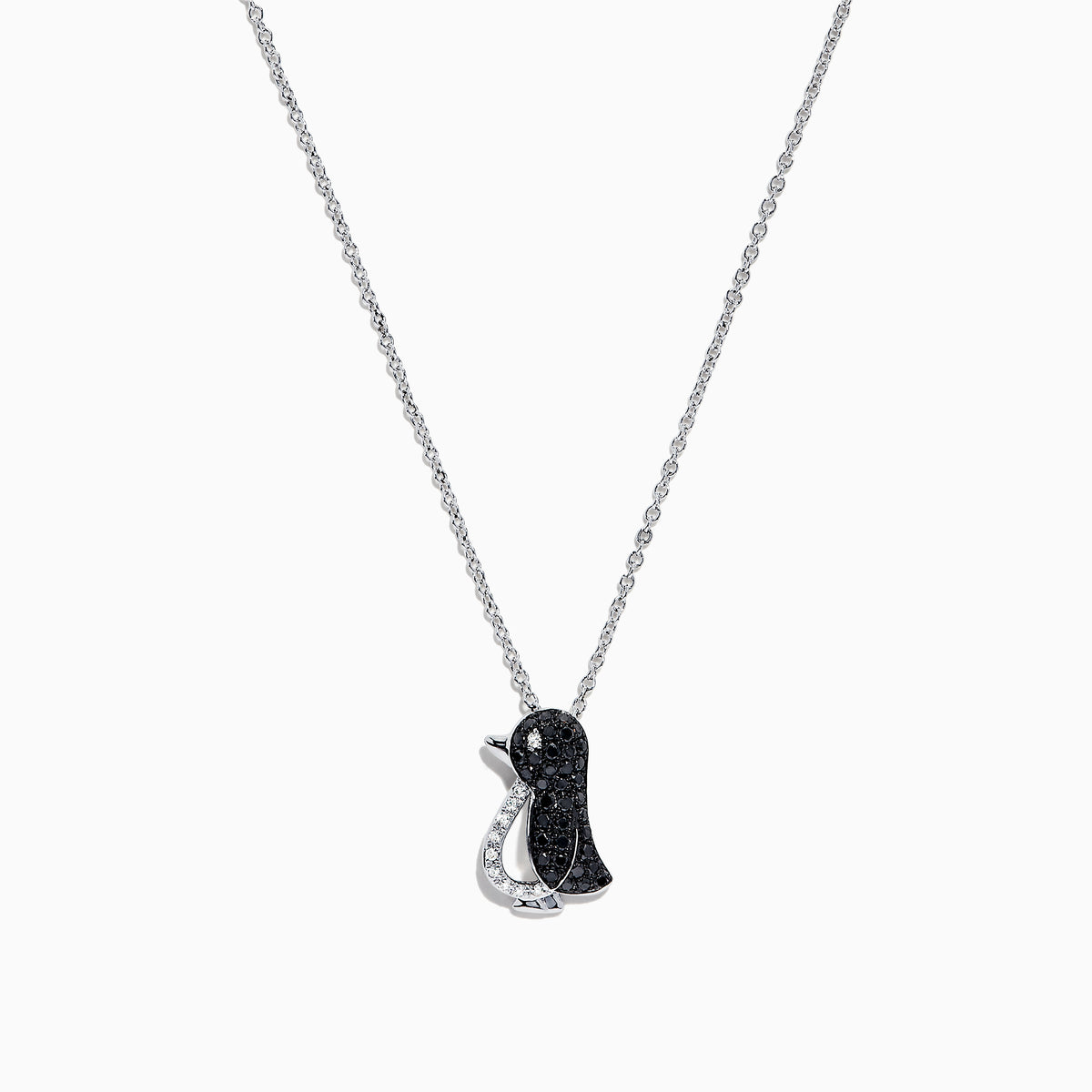The Safari Sterling Silver Black and White Diamond Penguin Pendant (0.31 TCW) hangs from a delicate chain, its playful penguin design dazzling with black and white diamonds set in sterling silver against a white background.