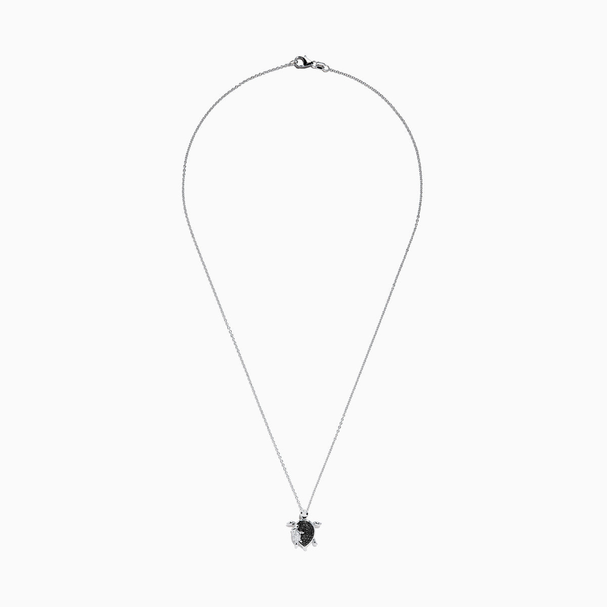 Introducing the Seaside Sterling Silver Black and White Diamond Turtle Pendant, 0.32 TCW—a stunning necklace featuring a turtle-shaped charm adorned with sparkling black and white diamond accents. A delicate silver baby turtle charm gracefully hangs from its side, adding a unique touch to this elegant design.
