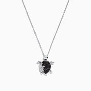 Introducing the Seaside Sterling Silver Black and White Diamond Turtle Pendant, 0.32 TCW—a stunning necklace featuring a turtle-shaped charm adorned with sparkling black and white diamond accents. A delicate silver baby turtle charm gracefully hangs from its side, adding a unique touch to this elegant design.