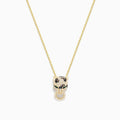 The Signature 14K Yellow Gold Diamond and Emerald Pendant features a panther’s head with diamond accents, emerald eyes, black detailing for spots, and a circular ring held in its mouth.