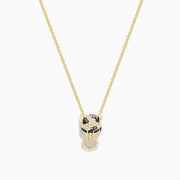 The Signature 14K Yellow Gold Diamond and Emerald Pendant features a panther’s head with diamond accents, emerald eyes, black detailing for spots, and a circular ring held in its mouth.