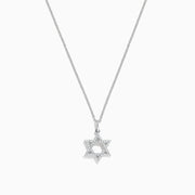 A dazzling Novelty 14K White Gold Diamond Star of David Pendant (0.14 TCW) is showcased against a simple white background, highlighting its sparkling elegance.