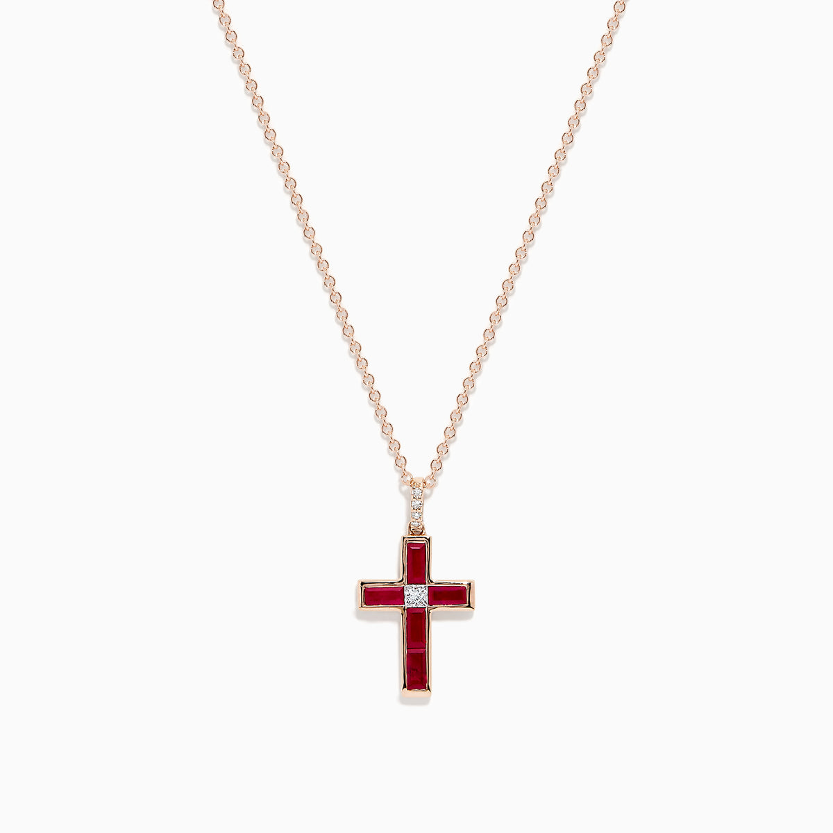 The Ruby Royale 14K Rose Gold Ruby and Diamond Cross Pendant, featuring a small clear center stone, is displayed on a rose gold chain against a white background.