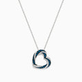The Bella Bleu 14K White Gold Blue and White Diamond Heart Pendant is a delicate necklace featuring sparkling blue and white diamonds, shown against a plain white background.