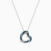 The Bella Bleu 14K White Gold Blue and White Diamond Heart Pendant is a delicate necklace featuring sparkling blue and white diamonds, shown against a plain white background.