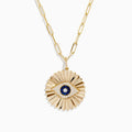 The Novelty 14K Yellow Gold Sapphire and Diamond Evil Eye Disk Pendant features a sunburst design with a sapphire center, diamond accents, gold spikes, and elongated oval chain links.