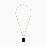The Mens 14K Yellow Gold Onyx and Diamond Dog Tag Pendant, 1.00 TCW, features a rectangular onyx with gold edges, a small gold emblem at the base, and three diamonds set on the bail.