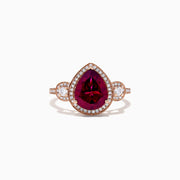 The Bordeaux 14K Rose Gold Rhodolite Garnet and Diamond Ring (3.32 TCW) features a pear-shaped Rhodolite Garnet, diamond halo, and round diamond clusters on each side, all set on a rose gold band.