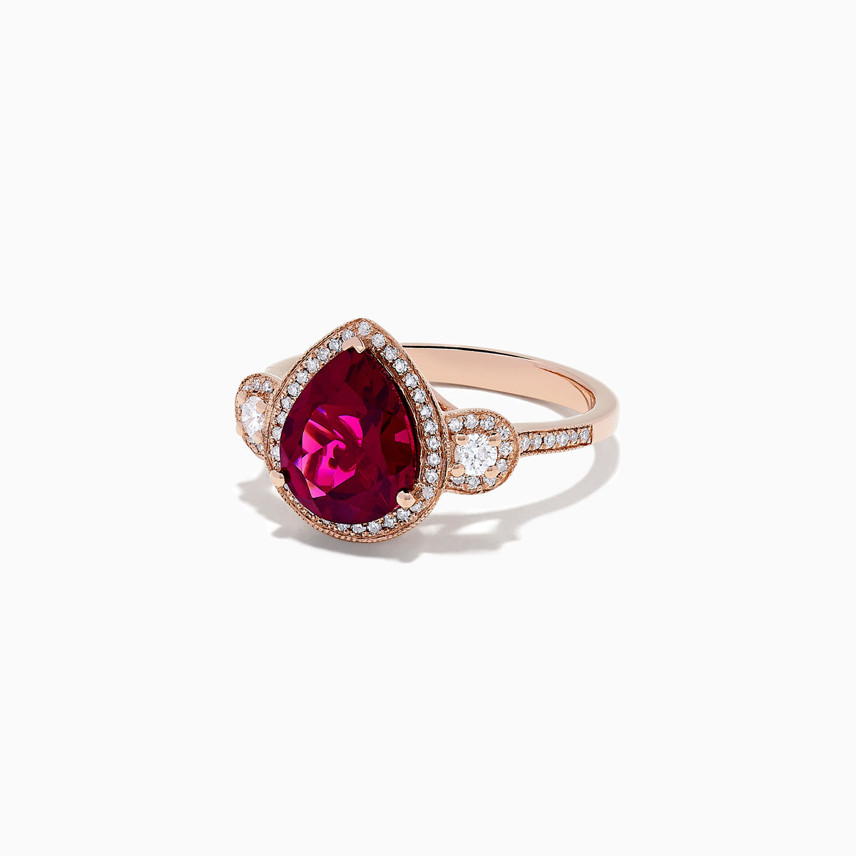The Bordeaux 14K Rose Gold Rhodolite Garnet and Diamond Ring (3.32 TCW) features a pear-shaped Rhodolite Garnet, diamond halo, and round diamond clusters on each side, all set on a rose gold band.
