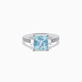 The Aquarius 14K White Gold Diamond and Aquamarine Ring showcases a square light blue aquamarine center, two rectangular clear side stones, and sparkling white diamond accents along the band.
