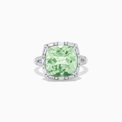 The 14K White Gold Green Amethyst and Diamond Ring showcases a cushion-cut green amethyst center, accented by a halo of clear baguette and round diamonds, all set in white gold.