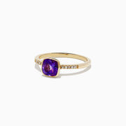 The 14K Yellow Gold Amethyst and Diamond Ring, 0.75 TCW features a cushion-cut amethyst center accented by round diamonds set into the band on each side.