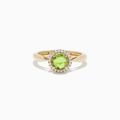 The 14k Yellow Gold Peridot and Diamond Ring, 1.10 TCW, showcases a round green peridot center encircled by a halo of sparkling diamonds, all set in yellow gold and displayed against a white background.