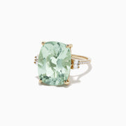 The 14K Yellow Gold Green Amethyst and Diamond Cocktail Ring (10.51 TCW) showcases a striking rectangular green amethyst center, accented by small diamonds on each side, set against a white background.