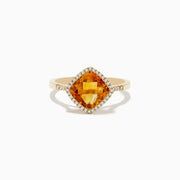 The Sunset 14K Yellow Gold Citrine and Diamond Ring features a cushion-cut citrine center stone encircled by a halo of sparkling white diamonds, displayed on a white background.