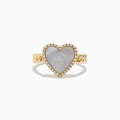 The Novelty 14K Yellow Gold Mother of Pearl and Diamond Heart Ring features a heart-shaped mother-of-pearl center, diamond accents, and a textured band, displayed on a white background.