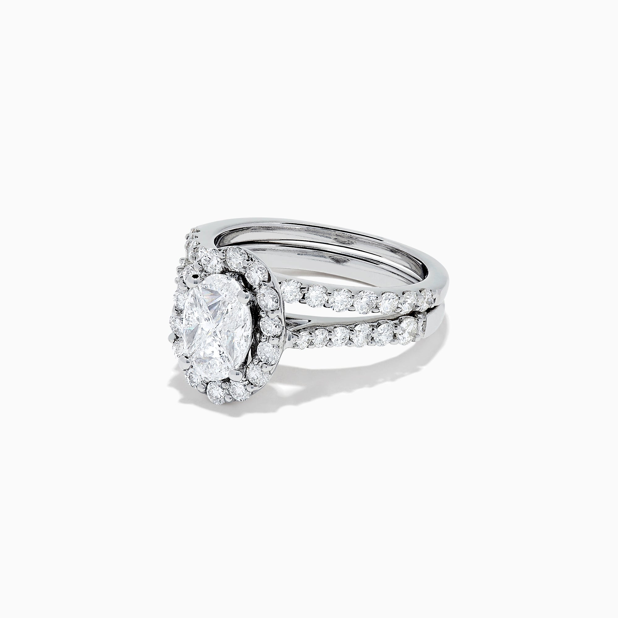 The 14K White Gold Diamond Ring and Matching Band Set, 2.00 TCW, features a large oval center diamond with a halo of round diamonds and a diamond-studded band—displayed against white, ideal for elegant bridal sets.