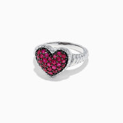 The 925 Sterling Silver Ruby Heart Ring, 1.02 TCW, showcases a heart-shaped centerpiece adorned with sparkling red stones set in silver against a white backdrop.