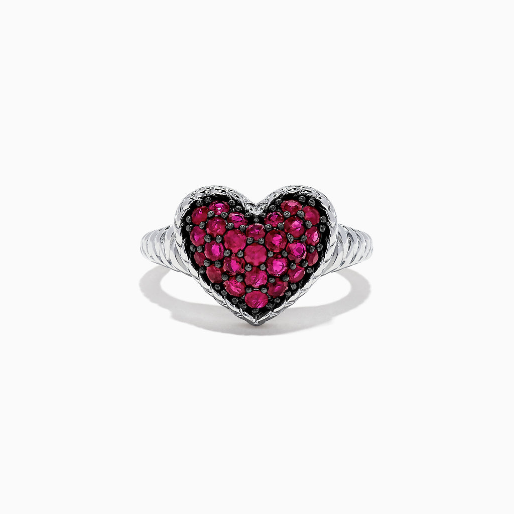 The 925 Sterling Silver Ruby Heart Ring, 1.02 TCW, showcases a heart-shaped centerpiece adorned with sparkling red stones set in silver against a white backdrop.